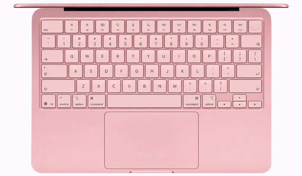 Top-down view of a pink MacBook Neo keyboard, large trackpad, and integrated Touch ID button, highlighting the primary input devices users interact with every day.